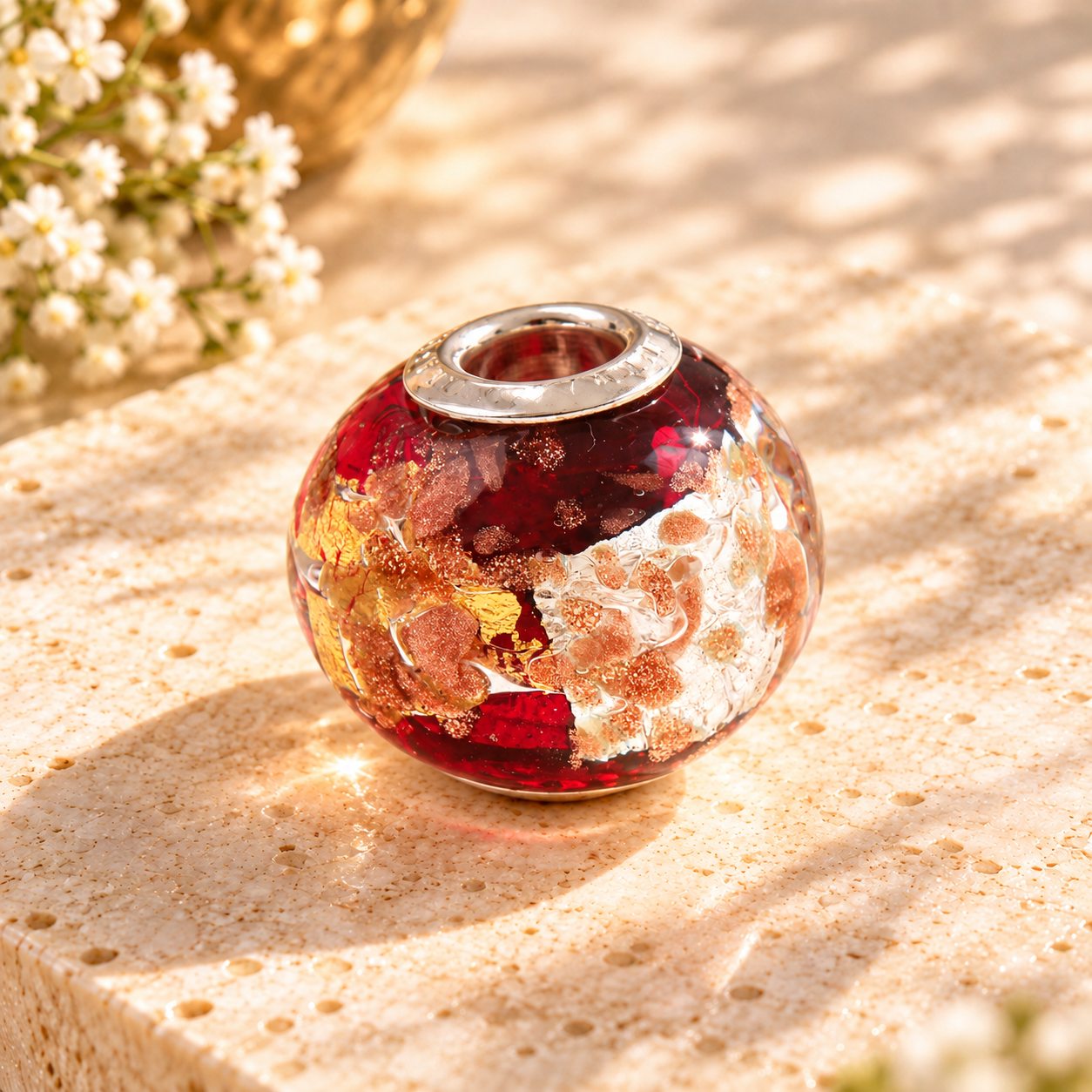 Rubinroter Muranoglas-Bead auf hellem Naturstein